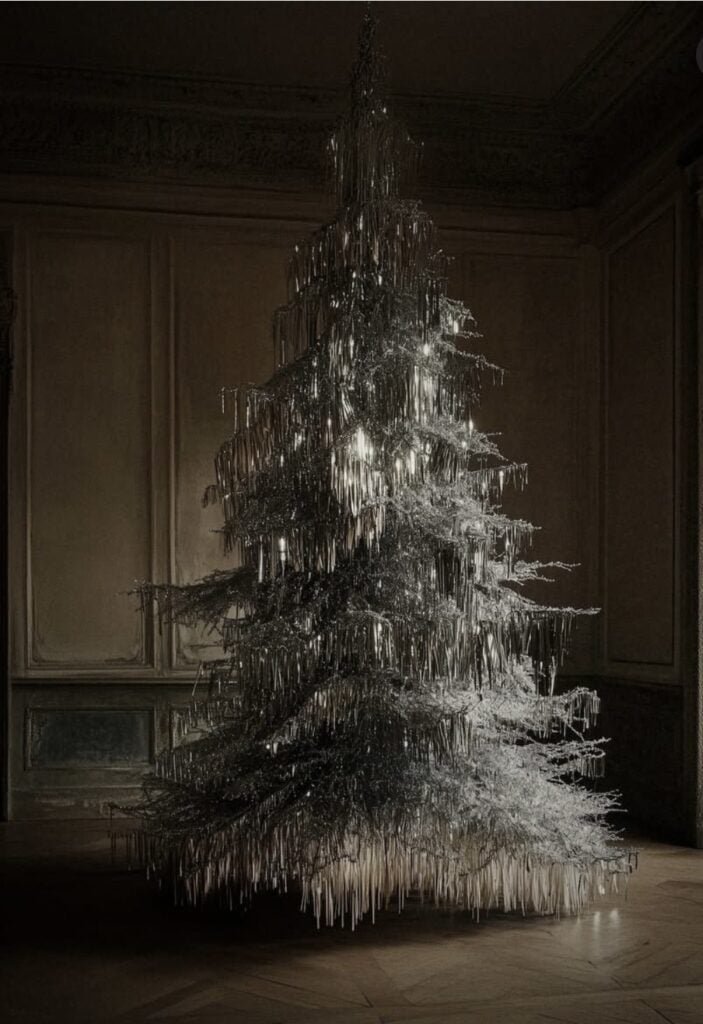 Elegant white Christmas tree decorated with long hanging icicles, white and silver ornaments, frosted branches, and sparkling lights.