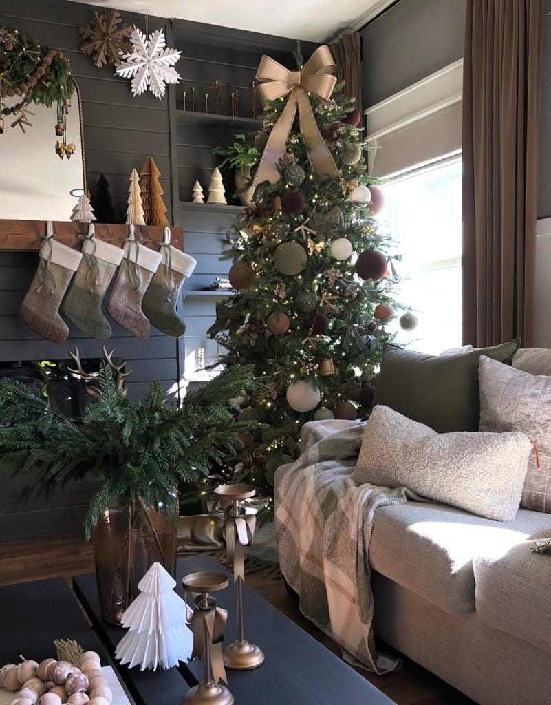 Neutral Christmas tree in a living room decorated with warm cream, brown, champagne, and natural holiday accents.