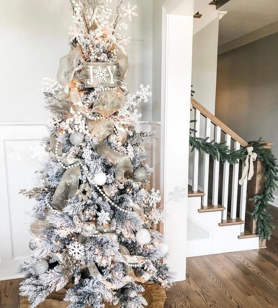 Neutral Christmas tree with farmhouse styling, natural textures, cream ornaments, rustic accents, and warm lights.