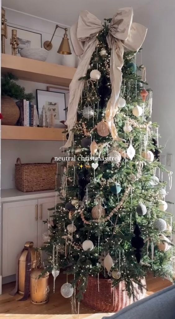 Neutral Christmas tree with a vintage feel featuring warm metallics, soft ornaments, traditional details, and layered textures.