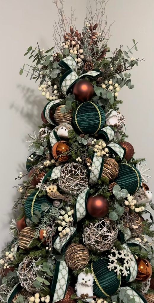 Neutral Christmas tree decorated with wooden ornaments, natural greenery, soft neutral colors, and organic textures.