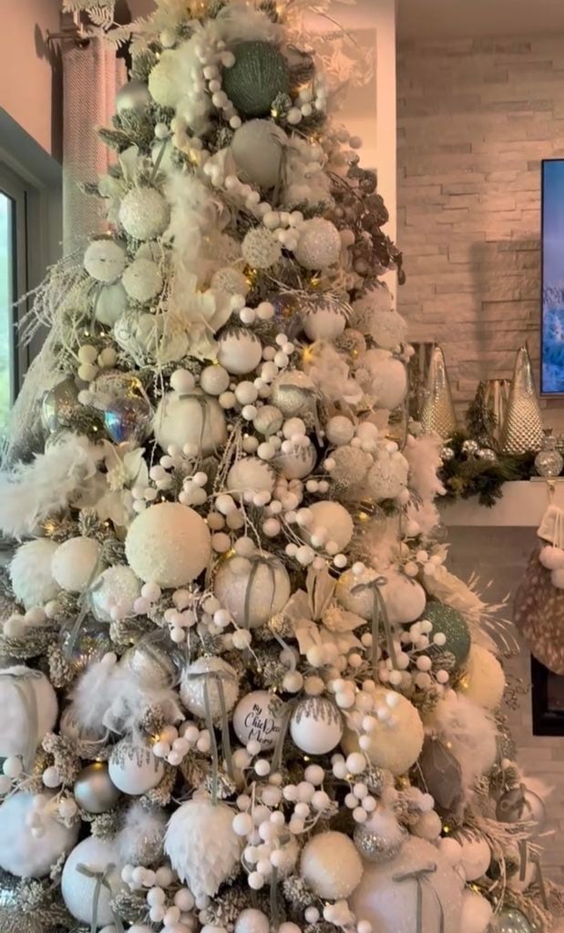 Elegant neutral Christmas tree decorated with soft champagne, cream, and gold ornaments and layered holiday details.