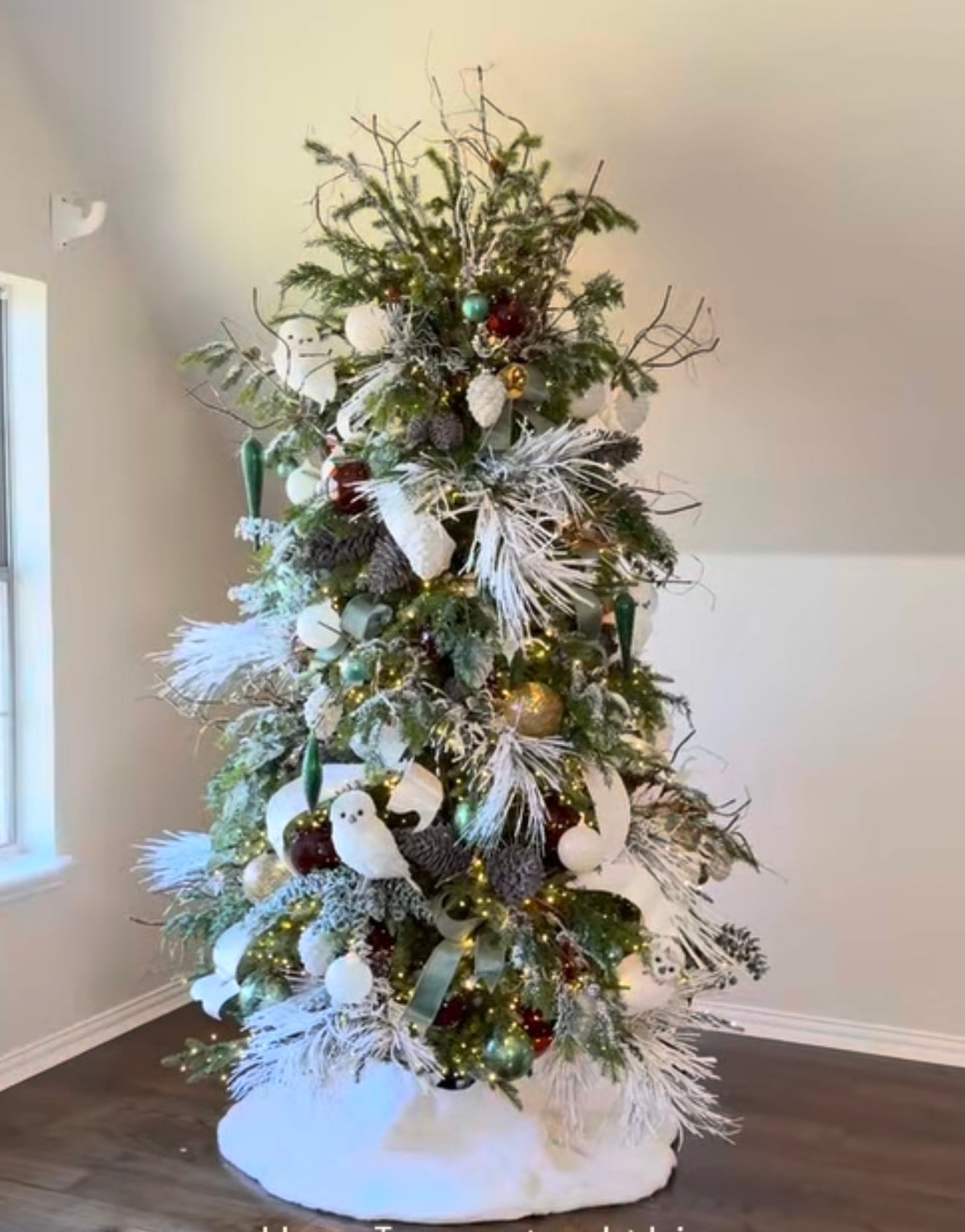 Organic neutral Christmas tree featuring natural greenery, soft neutral ornaments, textured branches, and earthy holiday styling.