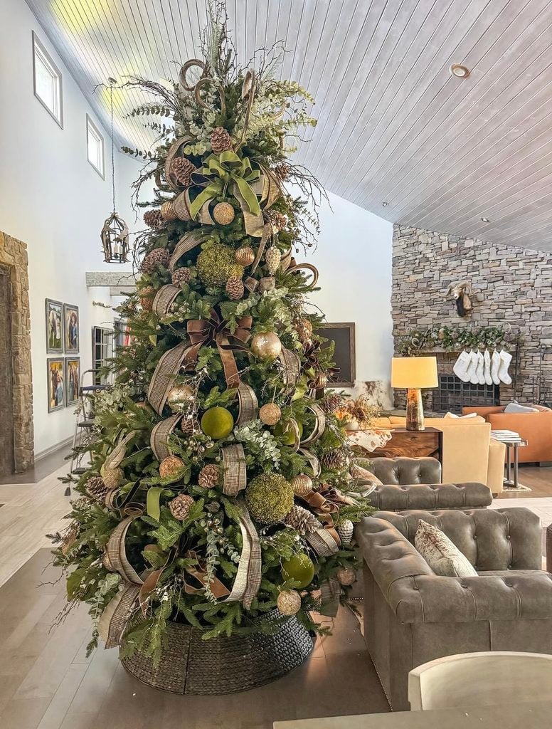 Organic neutral Christmas tree styled with greenery, natural materials, soft neutral ornaments, and earthy holiday details.
