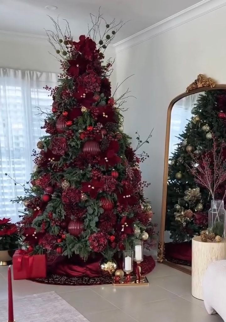 Elegant Bordeaux and burgundy Christmas tree layered with deep wine ornaments, greenery, ribbon and natural stick elements