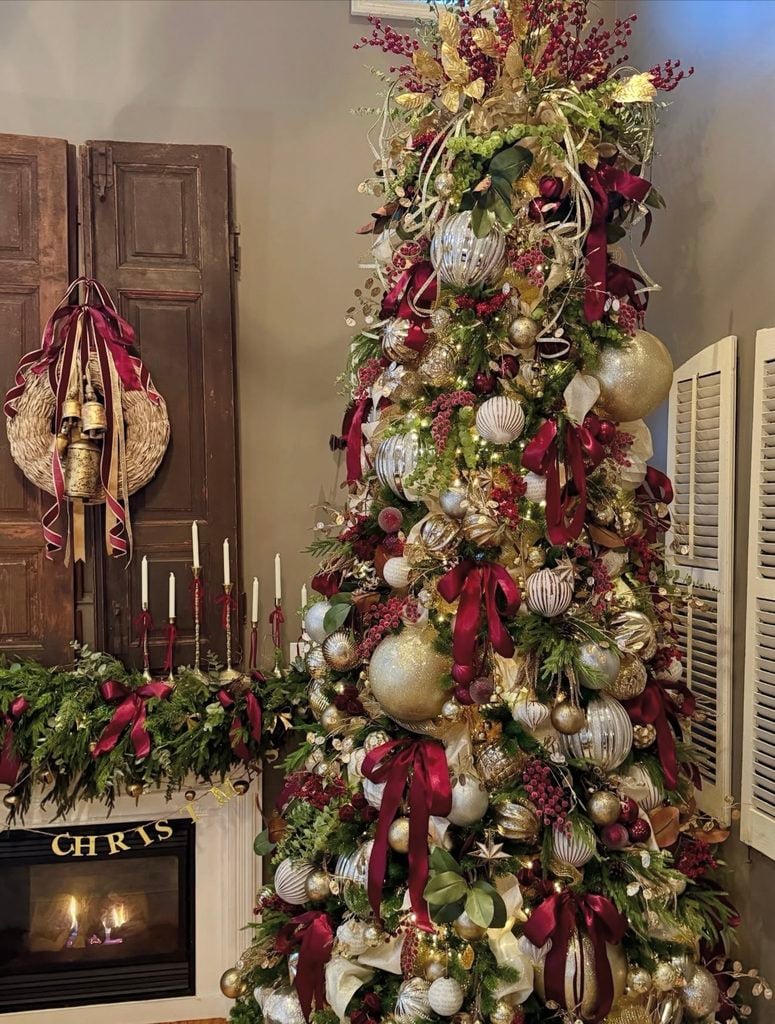 Rich burgundy Christmas tree paired with gold ornaments and warm metallic details for a luxe holiday look.