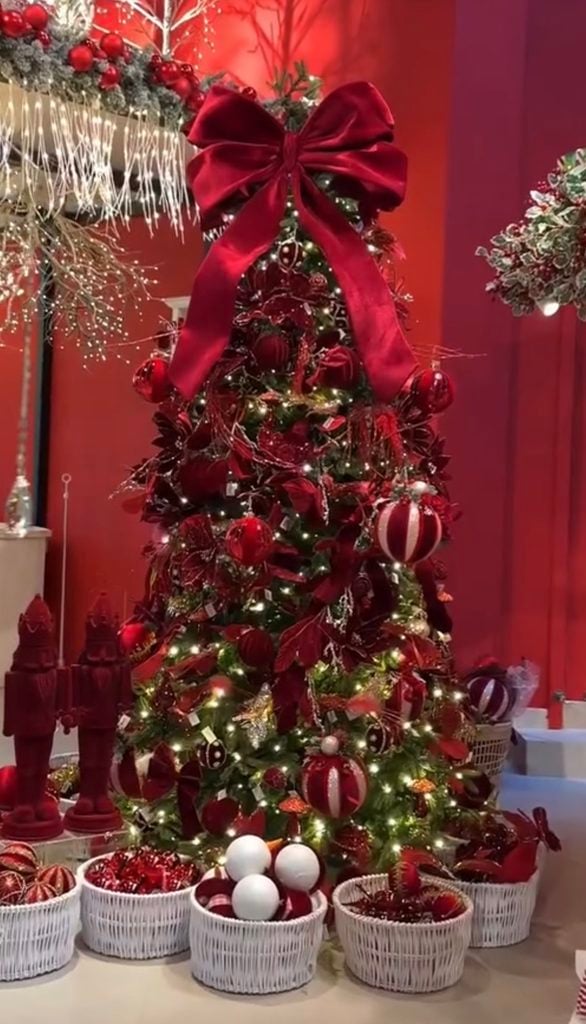 Red and burgundy Christmas tree mixing bright red and deep wine ornaments with greenery and warm white lights.