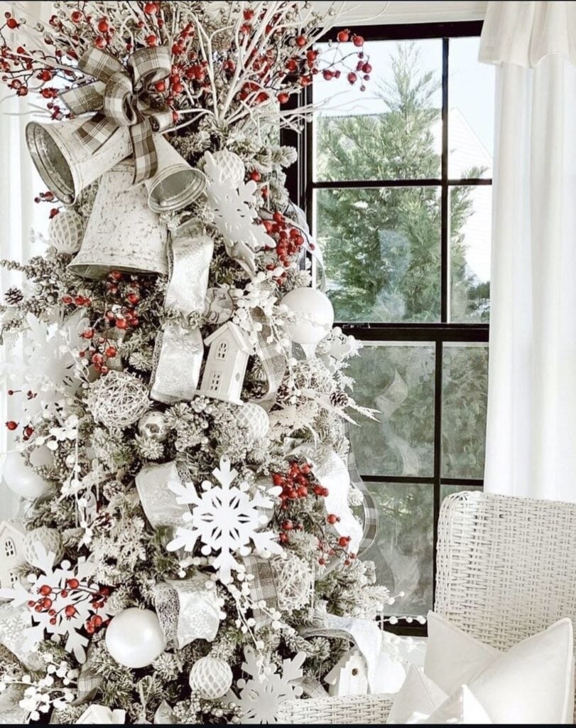 Rustic green Christmas tree decorated with white ornaments, snowy branches, natural textures, soft ribbon, and warm white lights.