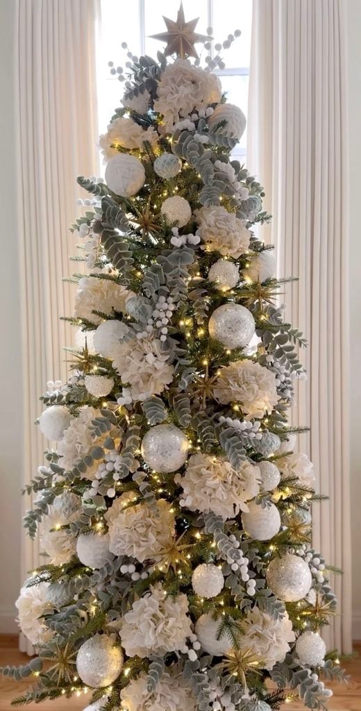 Neutral Christmas tree styling with layered cream, brown, green, and metallic decorations for added depth and dimension.