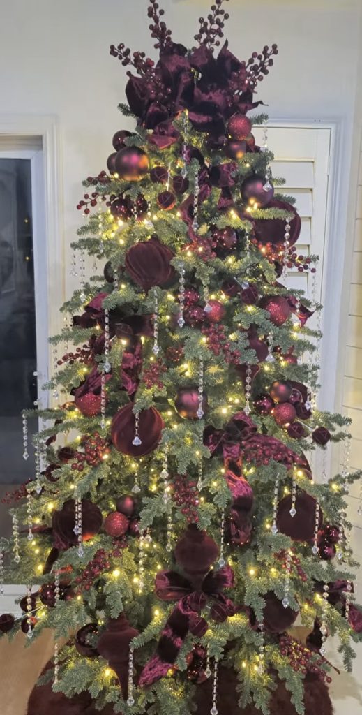 Trending burgundy Christmas tree decorated with rich wine ornaments, layered berries, velvet accents and warm lights.