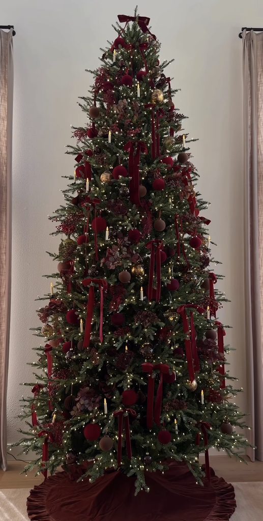 Understated burgundy Christmas tree with deep wine decorations, simple greenery and warm lights for an elegant holiday look.