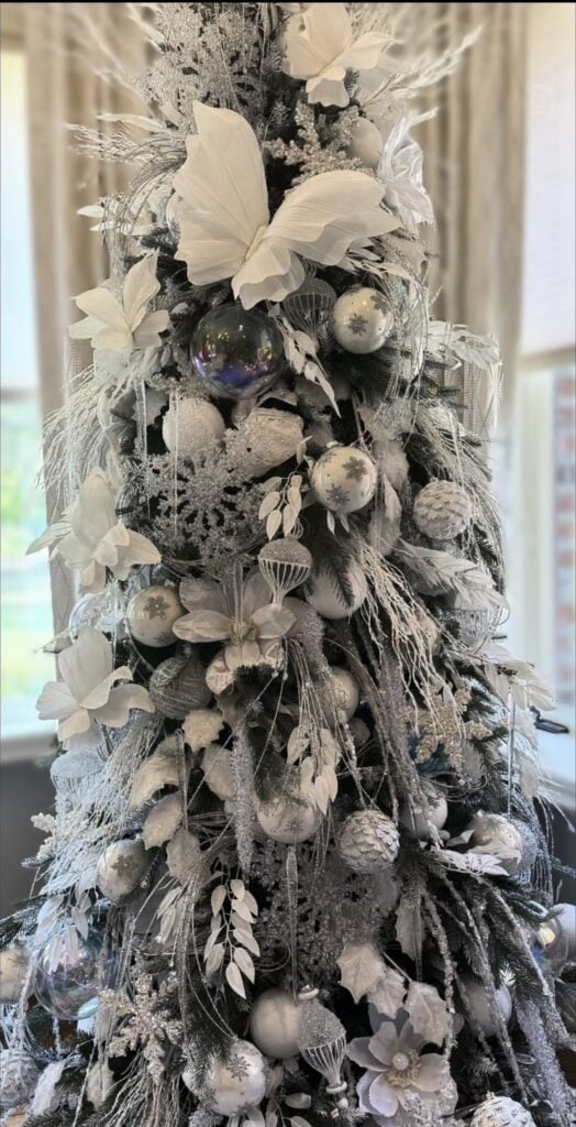 Whimsical white Christmas tree decorated with playful ornaments, soft snowy details, imaginative accents, layered textures, and glowing lights.