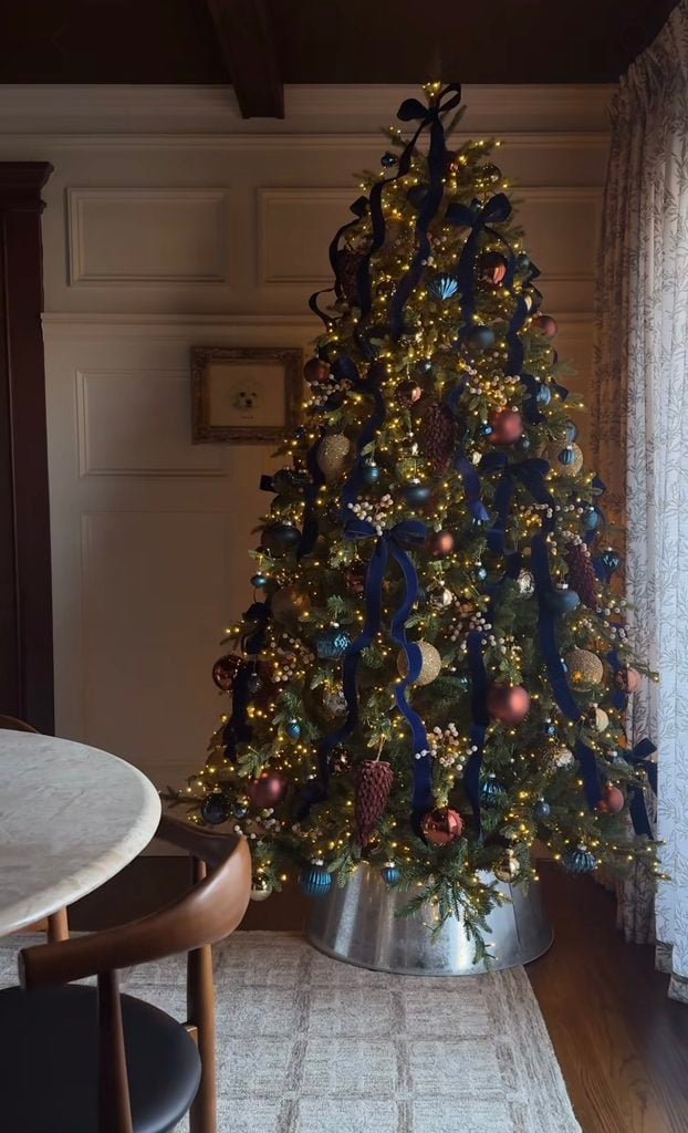 Ralph Lauren Christmas tree decorated with navy and blue plaid bows, burgundy accents, metallic ornaments, red berries, and warm white lights.