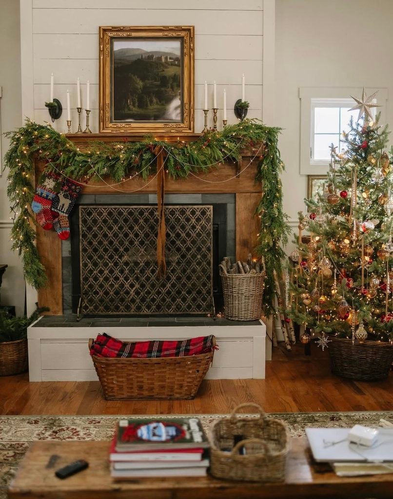 Christmas fireplace mantel decorated with greenery and stockings beside a coordinating Christmas tree in the living room.