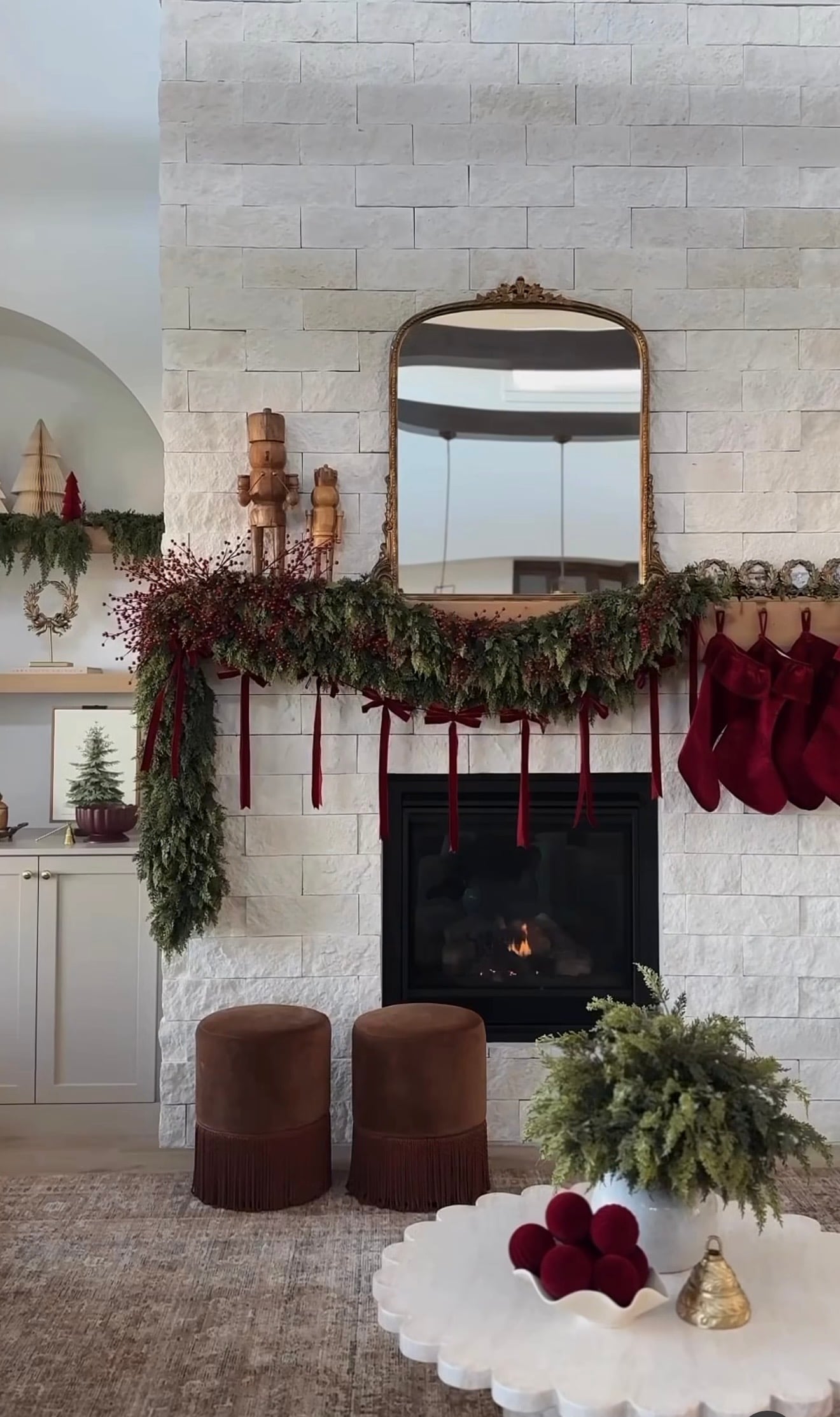 Modern Ralph Lauren Christmas mantel styled with with stockings, greenery, velvet ribbons and candles