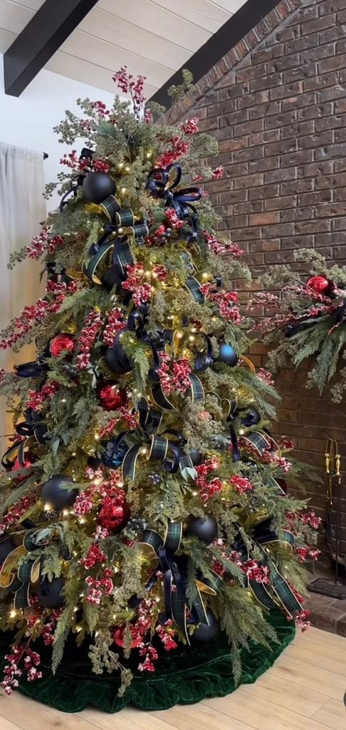 Nature-inspired Ralph Lauren Christmas tree decorated with plaid ribbon, pine cones, berries, greenery, warm metallic ornaments, and rustic woodland accents.