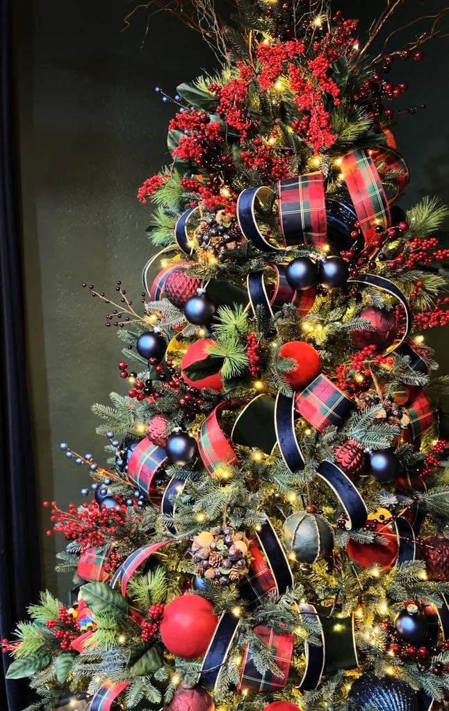 Ralph Lauren Christmas tree decorated with tartan plaid ribbon, navy velvet ribbon, red berry sprays, matte red and blue ornaments, pine greenery, and warm white lights.