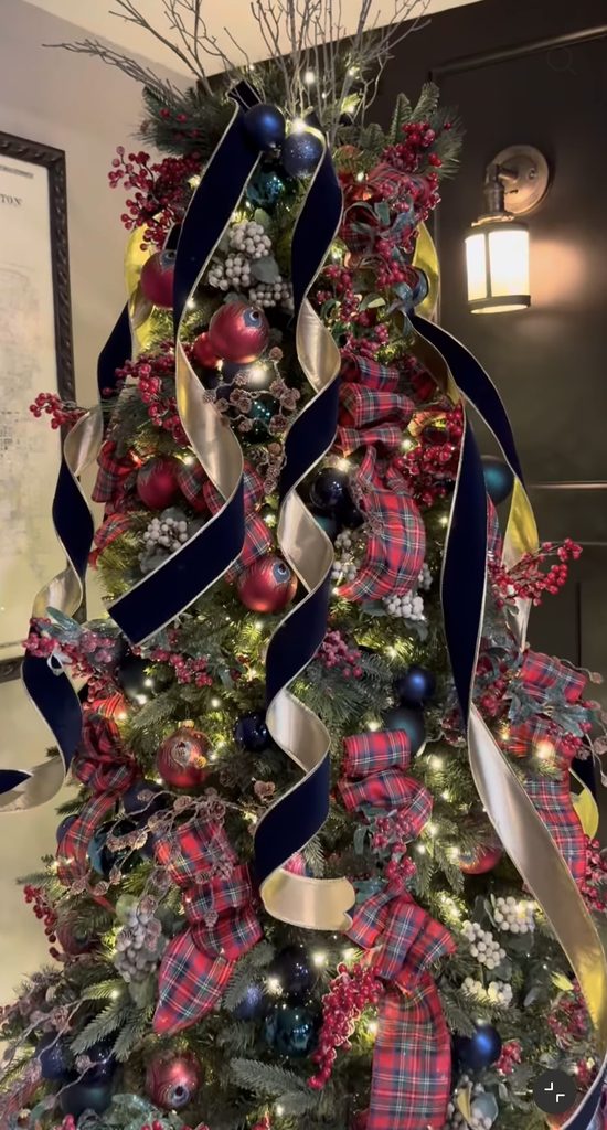 Ralph Lauren Christmas tree with dramatic navy velvet ribbon, tartan plaid bows, red berries, blue ornaments, white berry accents, and tall decorative branches.