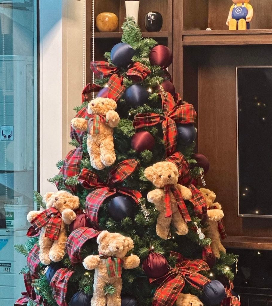 Ralph Lauren Christmas tree decorated with tartan bows, navy and burgundy ornaments, teddy bears, deep green branches, and classic preppy holiday details.