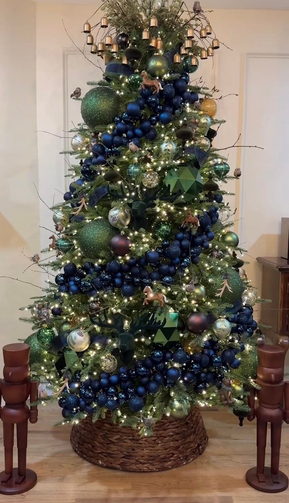 Ralph Lauren-inspired Christmas tree decorated with tartan ribbon, burgundy and navy ornaments, red berries, brass accents, warm lights, and layered traditional holiday decor.
