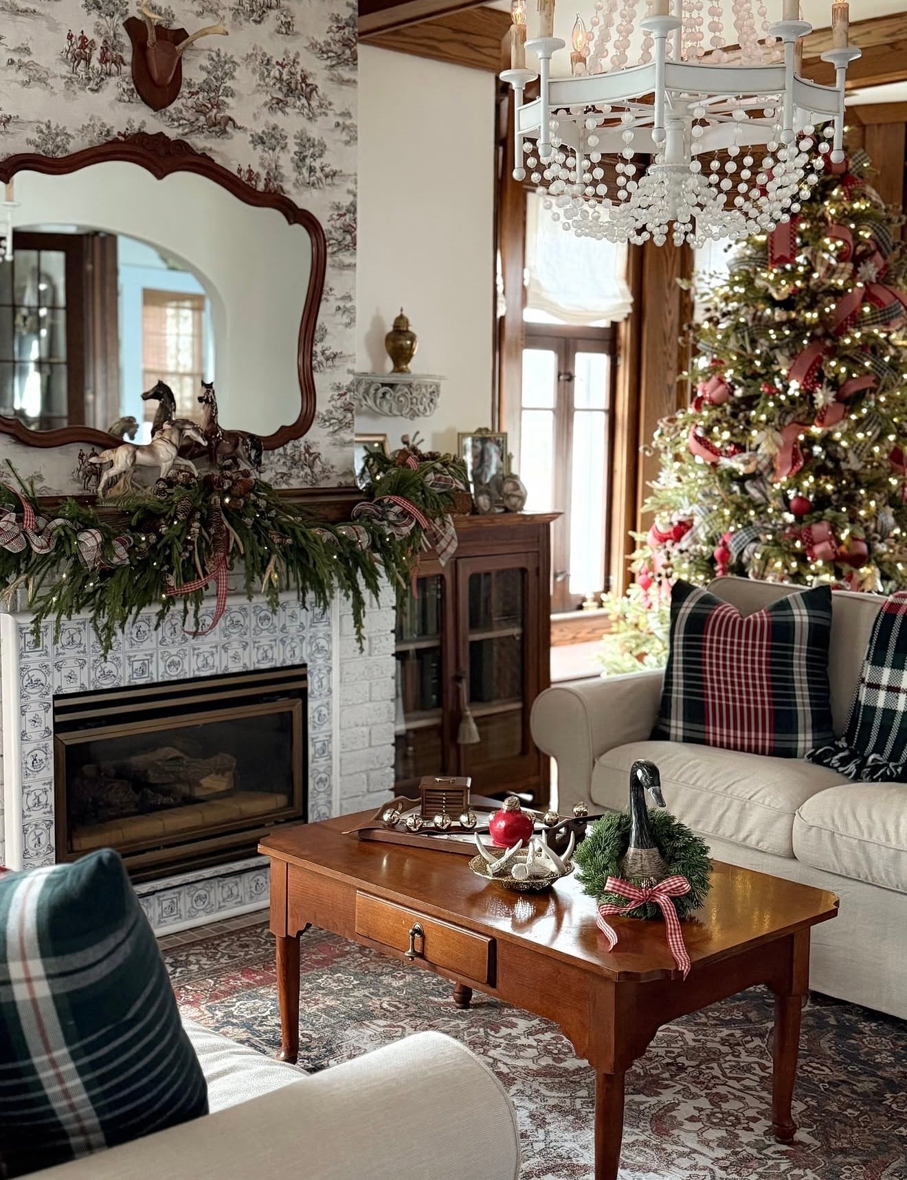 Ralph Lauren-inspired Christmas living room with tartan pillows, warm wood furniture, a decorated Christmas tree, fresh greenery on the mantel, equestrian accents, and classic holiday decor.