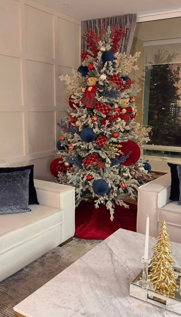 Flocked Ralph Lauren Christmas tree decorated with burgundy, navy, and red ornaments, plaid ribbon, velvet accents, berries, and warm metallic details.