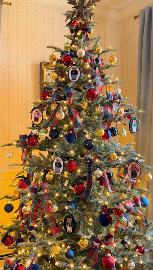 Ralph Lauren Christmas tree decorated with plaid bows, red, navy, and gold ornaments, Polo bear ornaments, warm lights, and classic preppy holiday details.
