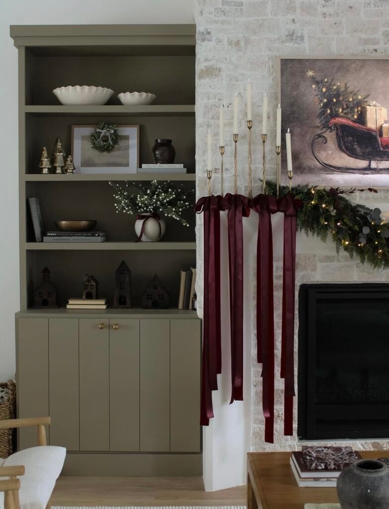 Elegant modern home Christmas mantel styled with Ralph Lauren aesthetic with ribbon, candles, greenery, and simple classic holiday styling.