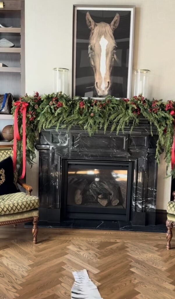 Ralph Lauren-inspired Christmas mantel with classic holiday styling, rich greenery, and traditional decorative accents and horse picture above fireplace