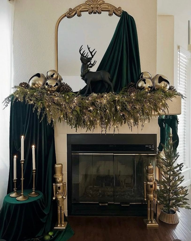 Dark green and gold Christmas fireplace mantel with rich greenery, metallic accents, candles, and elegant holiday decorations.