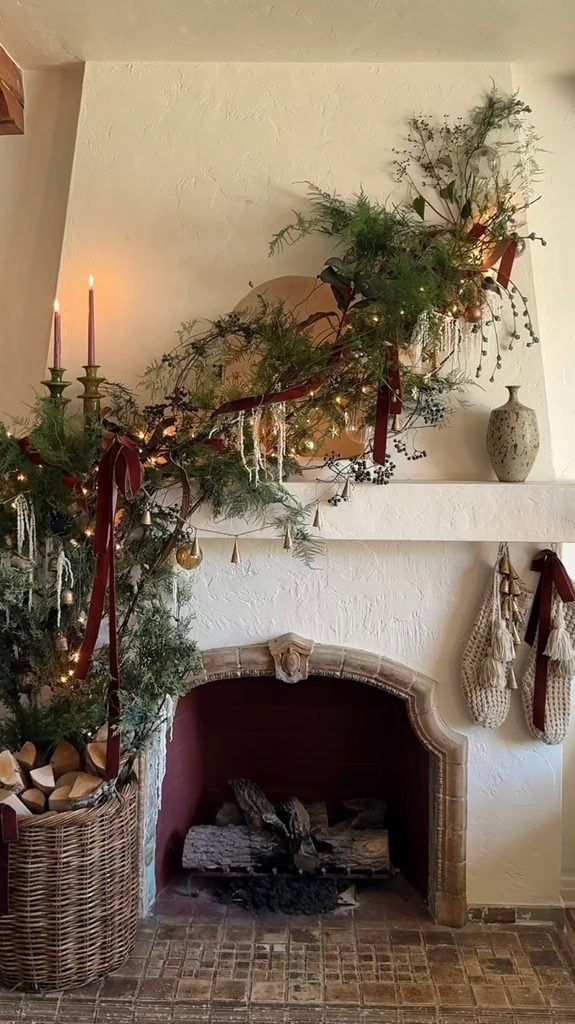 Modern Christmas fireplace mantel with sculptural greenery, simple holiday decorations, and a clean contemporary look.
