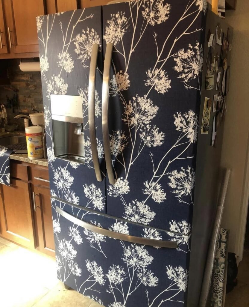 Refrigerator covered in dramatic patterned wallpaper to create a focal point in the kitchen.