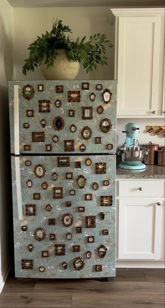 Maximalist wallpapered fridge gallery wall with blue botanical wallpaper and dozens of tiny ornate vintage frames arranged across both refrigerator doors.