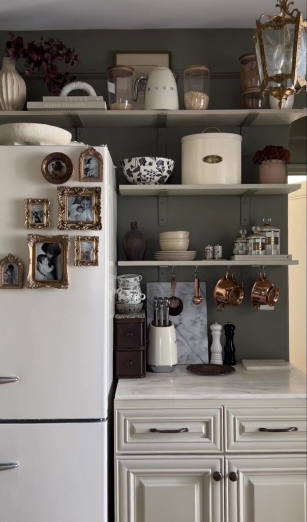 Vintage-inspired fridge gallery wall on a white refrigerator with black-and-white family photos displayed in ornate antique-style gold and bronze frames.