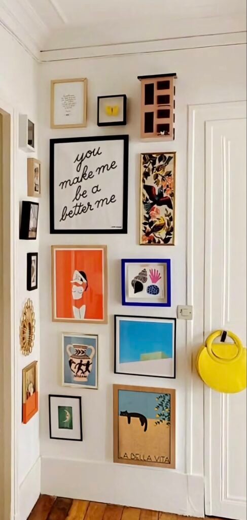 Colorful floor-to-ceiling gallery wall with eclectic artwork, framed cat art and bright modern accents.